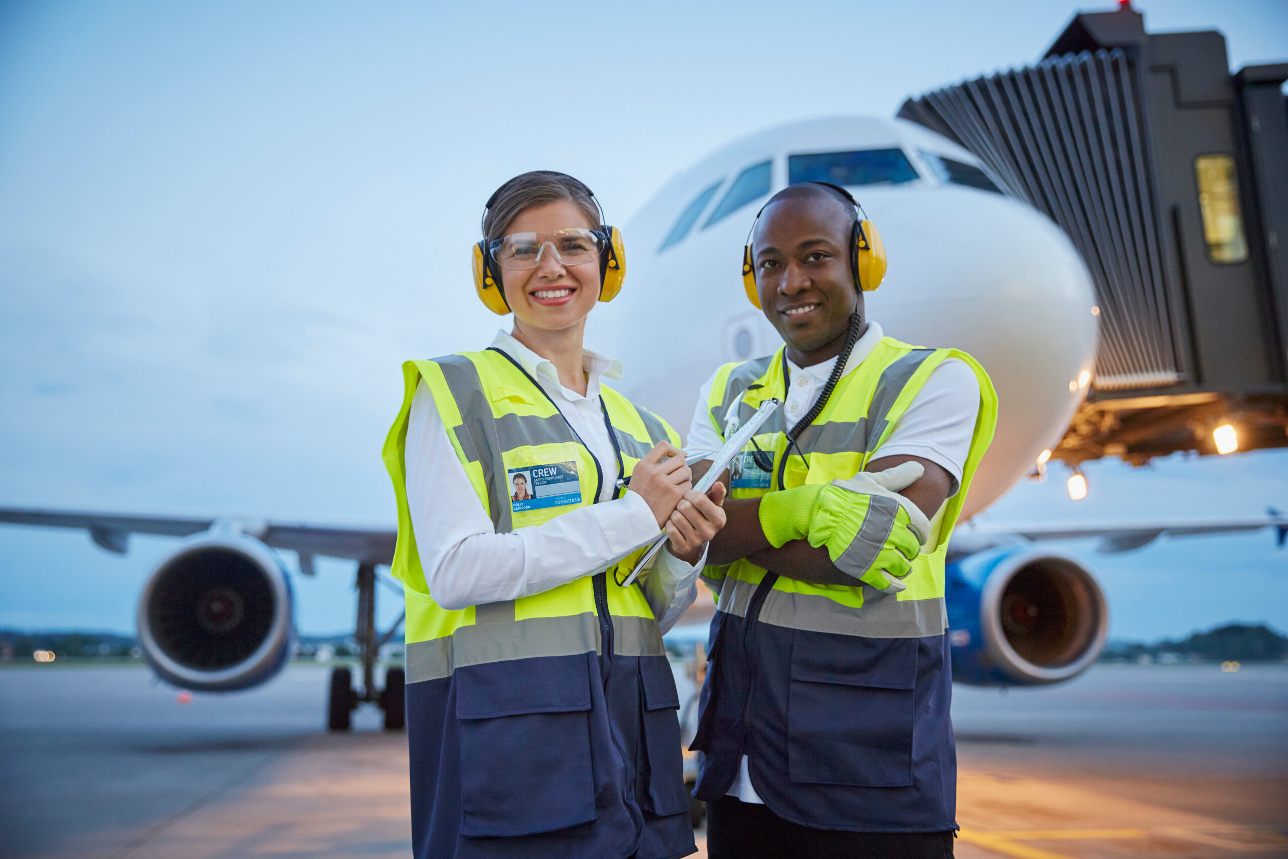 Portrait confident air traffic control ground crew workers near airplane on airport tarmac